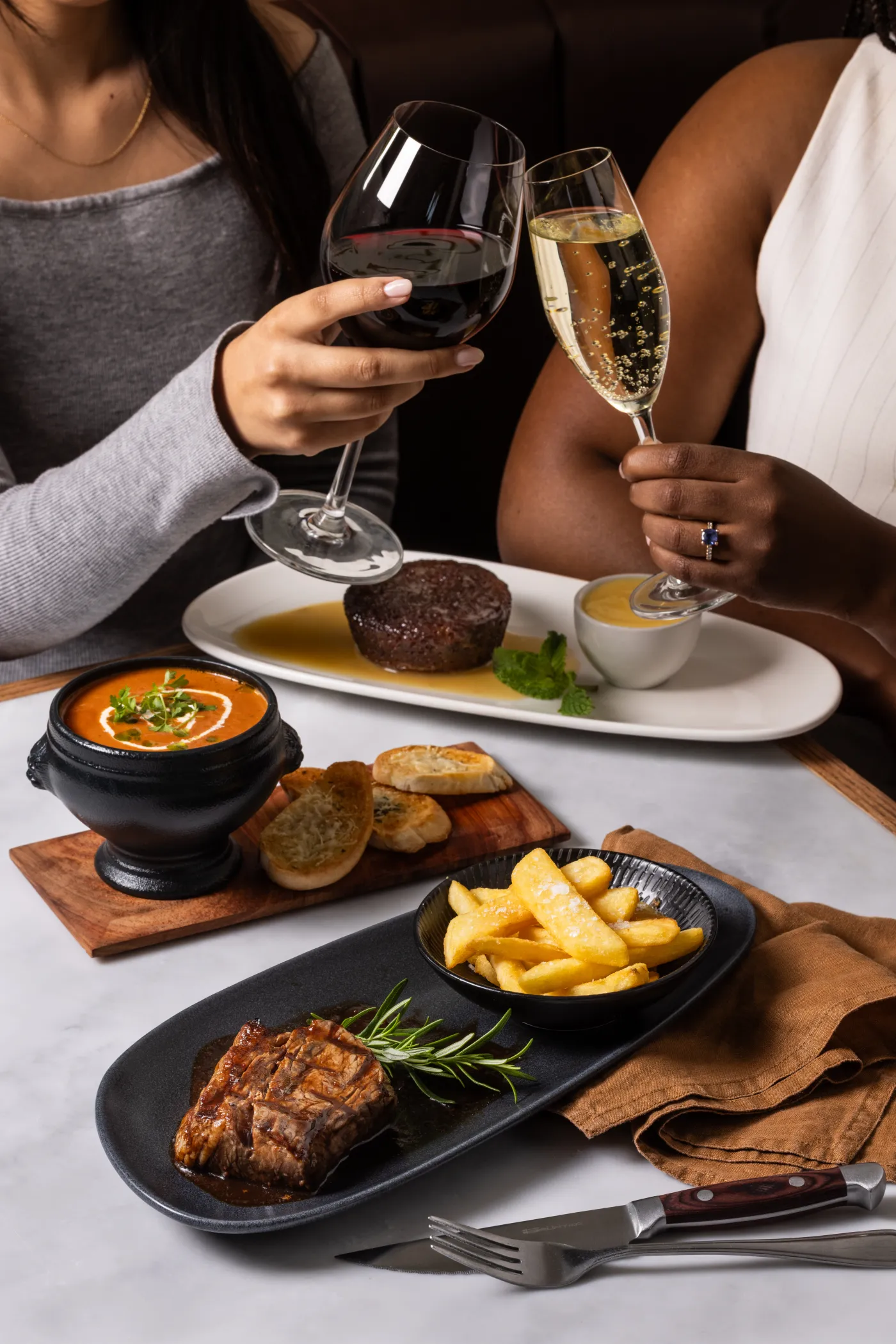 Two glasses of wine raised over dinner