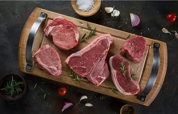 Raw Class-A cuts on a wooden board before grilling