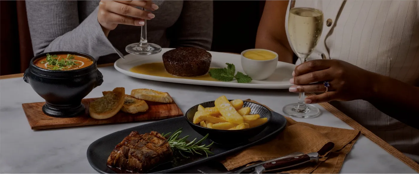 A set menu for two with soup, steak and a glass of white wine