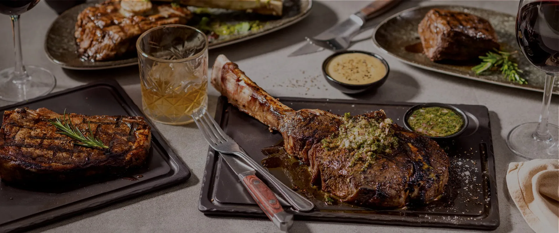 A tomahawk and grills spread across a Hussar Grill table